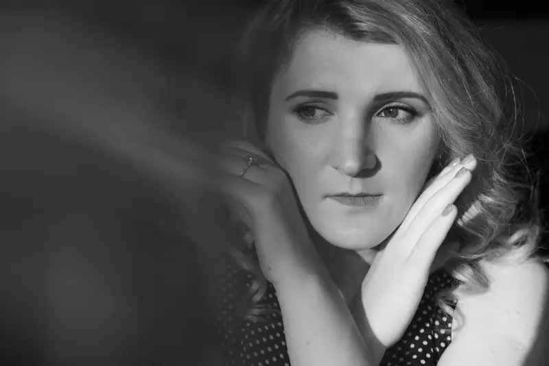 Zwart-witportret van een vrouw in een gestippelde blouse